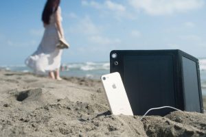 Holy Plug sulla riva del mare con iPhone in carica